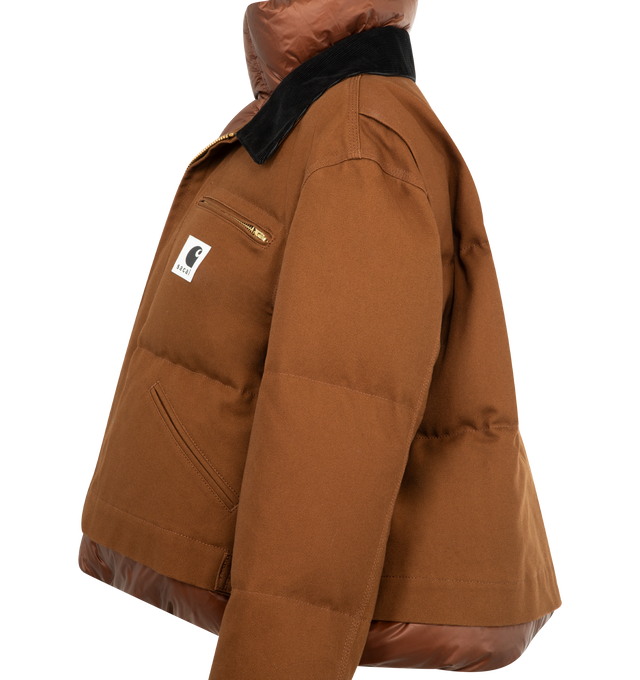 Image 3 of 3 - BROWN - Sacai x Carhartt WIP Duck Puffer Jacket in a boxy, cropped fit and layered silhouette combining a signature canvas exterior with a plush quilted nylon interior. Features stand collar and spread collar, long sleeves, elasticized snap cuffs, chest zip pocket, side patch pockets, concealed snap, two-way front zip closure, finished with a co-branded woven label. Cotton outer, 100% nylon and 100% cupro lining, 90% duck down/10% duck feather fill. Made in Japan. 