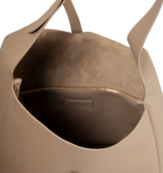 Image 3 of 3 - NEUTRAL - SAINT LAURENT Large Le 5  7 Supple featuring two main compartments, inner zip pocket, adjustable strap, open top with cassandre hook closure and suede lining. 11.8 X 12.2 X 5.1 inches. Handle drop: 11.8 inches. 100% calfskin leather. Made in Italy.  