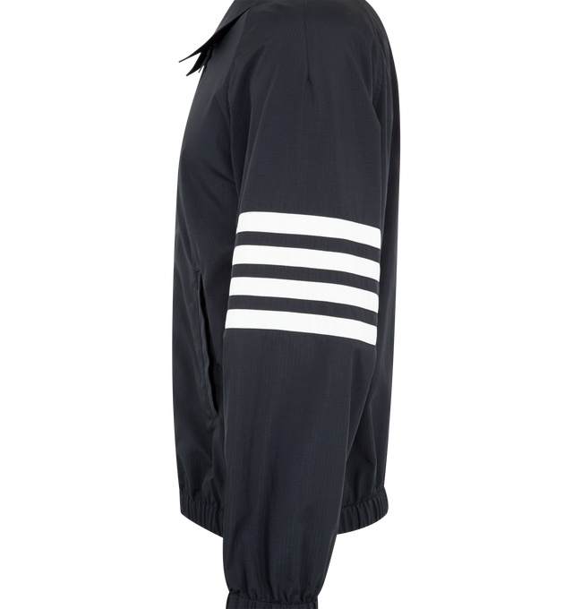 Image 3 of 3 - NAVY - THOM BROWNE Ripstop Raglan Coach Jacker featuring front two-way zip closure, raglan sleeves, welt hand pockets, one interior pocket, elasticated cuffs and hem, engineered 4-bar detailing and signature striped grosgrain loop tab. 81% polyamide, 19% polyester. Made in Italy. 