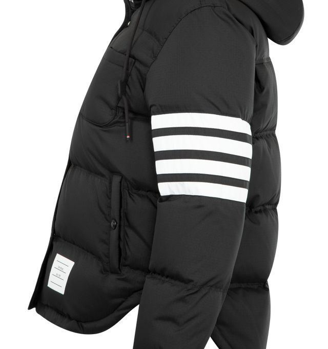 Image 3 of 3 - BLACK - THOM BROWNE Shiny Ripstop Lightweight Jacket featuring a lightweight, weather-resistant fabric, a shirtdress-inspired hem, front snap closure, drawstring hood with matte RWB-detailed aglets, patch chest pocket, welt hand pockets with snap, interior button pocket, snap-fastening cuffs, plain back yoke with locker loop, curved hem, tricolor lining, 4-bar detailing, name tag appliqu and signature striped grosgrain loop tab. 81% polyamide, 19% polyester. 80% white goose down, 20% white go 