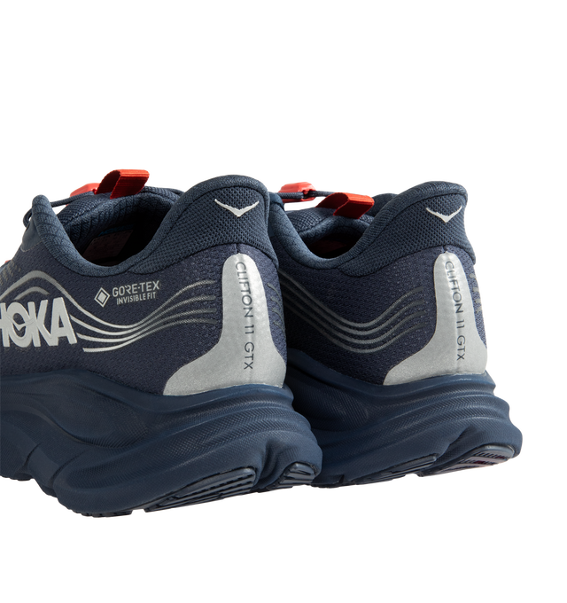 Image 3 of 5 - NAVY - Hoka Women's Clifton 11 GTX Running Sneakers feature a closed-mesh upper with a GORE-TEX Invisible Fit membrane and PFC-free water-repellent treatment. An adjustable speed-lace system with toggle, reflective details, a compression-molded EVA midsole, and a Durabrasion rubber outsole with forefoot traction pods complete the weather-ready design. Upper: Mesh with GORE-TEX Membrane. Midsole: EVA Foam. Sole: Rubber. Heel-to-Toe Drop: 8 mm. 