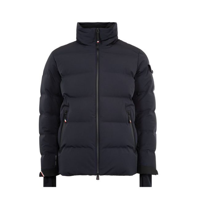 Image 2 of 4 - NAVY - MONCLER GRENOBLE Montgetech Down Jacket featuring a 2 way zip front closure, stand collar, removable hood, wrist gaiters, thumbhole cuffs, and an interior powder skirt. Lined with down fill. 87% polyamide/nylon, 13% elastane/spandex. Lining: 100% polyester. Padding: 90% down, 10% feather. Made in Romania.  