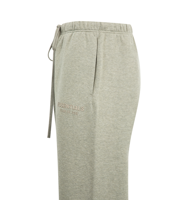 Image 3 of 3 - GREY - FEAR OF GOD ESSENTIALS Relaxed Fleece Sweatpant With Piping made from 380gsm core fleece featuring a relaxed straight leg fit. The embroidered "Essentials" script logo is placed on the leg, while a "Fear of God Essentials" rubberized label is situated at the center front. Key features include side pockets, ankle bungee, and an encased elastic waistband with drawstrings for adjustability. 80% cotton, 20% polyester fleece. 