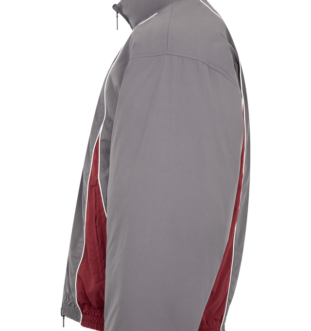 Image 4 of 4 - GREY - BALENCIAGA Reversible Tracksuit Jacket featuring cotton-like polyamide, reversible design: one smoky purple side with contrasting yokes, one plain black side, high neck, front zip closure, long sleeves, 2 zipped slash pockets on the smoky purple side, 2 snap slash pockets on the black side, elasticated cuffs and waistband and loop sports icon embroidered on chest on both side. 100% polyamide. 100% polyester. Filling: duck down. Made in Italy. 