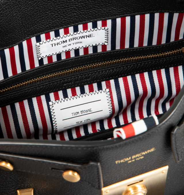 Image 4 of 4 - BLACK - THOM BROWNE Bolton Bag featuring padlock flap closure, top handles, key bell with RWB grosgrain trim, detachable adjustable leather shoulder strap, detachable RWB ribbon-woven chain strap, RWB stripe on front and back, adjustable side gussets with belt and stud details, interior zip pocket, slip pocket, and two smaller slip pockets, tricolor lining and signature striped grosgrain loop tab. L 33 x W 15 x H 35 cm. 100% calf full grain leather. Lining: 100% polyester. Made in Italy. 