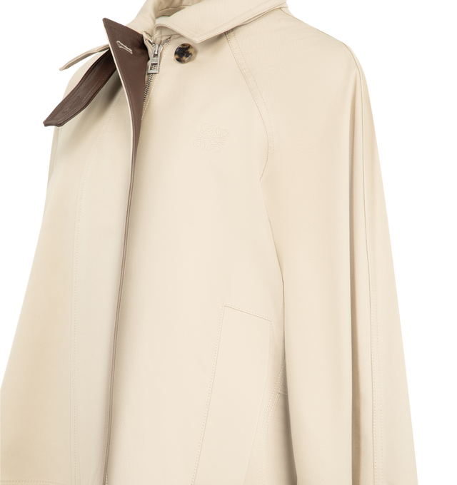 Image 4 of 4 - NEUTRAL - LOEWE Short Parka in lightweight cotton and silk gabardine featuring a high neck with a leather chin strap and a storm flap, relaxed fit, regular length, concealed zip front fastening, raglan sleeves, buttoned tabs at the waist and cuffs, diagonal welt pockets and anagram embroidery placed on the chest. Cotton/silk. Made in Portugal. 