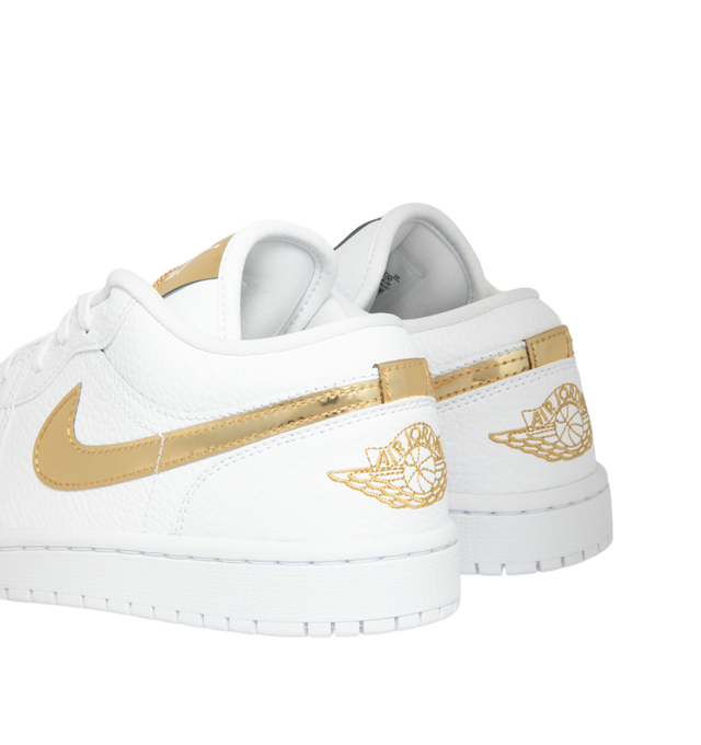 Image 3 of 5 - GOLD - Women's Air Jordan 1 Low SE Sneakers feature a genuine leather upper with signature stitched overlays, a low-top silhouette, and iconic Wings branding for a timeless look. These lifestyle sneakers combine lightweight Air-Sole cushioning, a supportive cupsole construction, and a durable rubber outsole for everyday comfort, stability, and reliable traction. Main Material: Genuine Leather. Midsole: Foam with Air-Sole Unit. Sole: Rubber. 