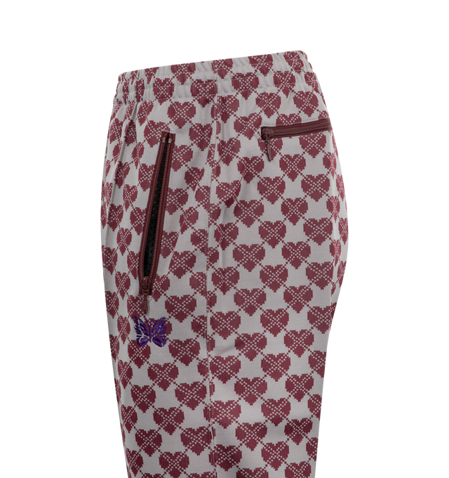 Image 3 of 3 - RED - Needles Jacquard Heart Track Pants are a pull-on style with an internal drawstring, side zip pockets, a rear zipper pocket, and an embroidered brand butterfly. 100% polyester. Made in Japan.  