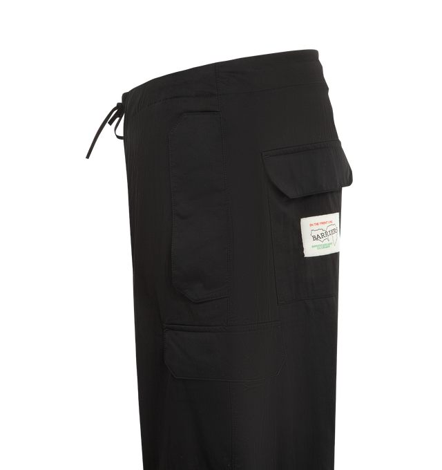 Image 3 of 3 - BLACK - BARRIERS WORLDWIDE Star Nylon Pant featuring nylon overpant with adjustable drawstring waist, adjustable drawstring leg opening, patch pockets at front and back and star stitch detailing at center back waistband. Nylon. 