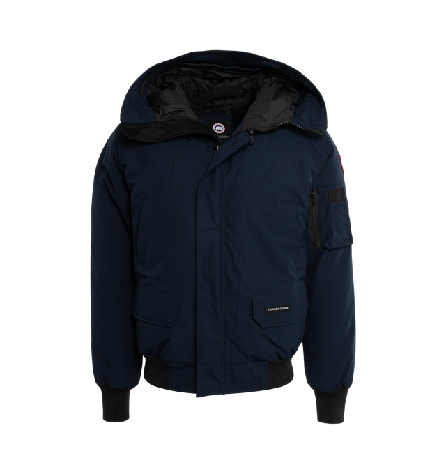 Image 1 of 2 - NAVY - CANADA GOOSE Chilliwack Down Jacket featuring detachable trim at hood, funnel neck, two-way zip closure and press-stud placket, welt and flap pockets, rib knit hem and cuffs, raglan sleeves, logo patch and utility pocket at sleeve, zip pocket and patch pockets at interior, elasticized shoulder straps at interior and full nylon satin lining. 84% polyester, 16% cotton. Lining: 100% polyamide. Fill: 80% duck down, 20% duck feathers. Made in Canada. 