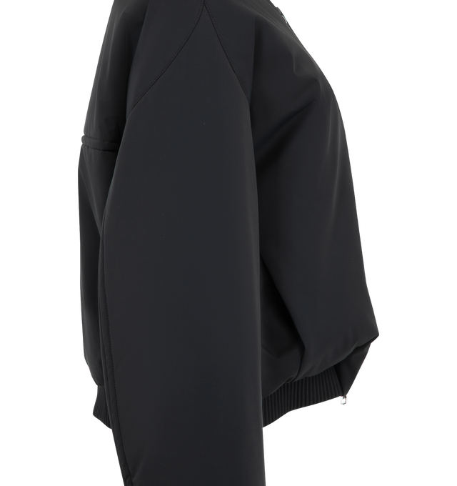 Image 3 of 4 - BLACK - Khaite Womens Cropped Bomber Jacket is crafted from double-face technical nylon. Features a cropped silhouette, front zip closure, rounded shape, signature armhole seaming, topstitched detailing, elasticized cuffs and hem, and in-seam side pockets. Main Material: 57% Nylon, 27% Polyurethane, 16% Elastane. Made in Italy. 