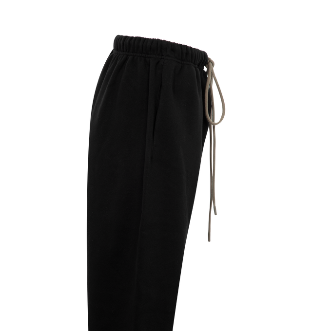 Image 3 of 3 - BLACK - Fear of God  Essentials womens sweatpant made in core fleece with a shorter inseam and a feminine silhouette.Featuring a soft touch logo on the leg, rubberized label at the center front, encased elastic waistband with elongated drawstrings with rubberized tips, side seam pockets and a new elastic ankle hem finished in a stretch binding. 80% cotton, 20% polyester brushed back fleece. 