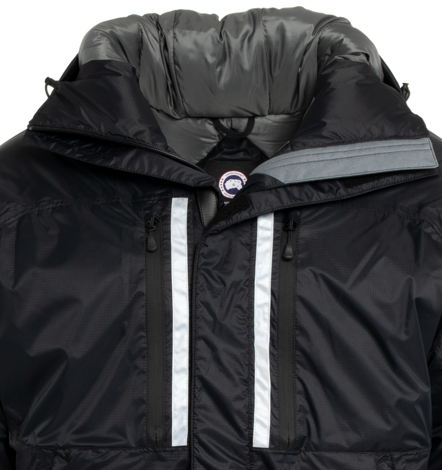 Image 3 of 3 - BLACK - CANADA GOOSE Skreslet Parka featuring 2 Napoleon chest pockets and 2 front pockets, both with water-repellent zipper closures, extra-long sleeves for coverage and mobility, fleece-lined chin guard, fully seam sealed for wind and wet weather protection, interior Pocket: 1 large inner lower mesh pocket designed to hold a water bottle, oversized down hood is adjustable and has a shaping wire for added protection and wide sleeve cuffs with Velcro closure for ease of use and venting. 100%  