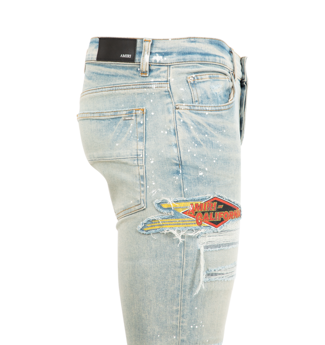 Image 3 of 3 - BLUE - AMIRI MA Cement Thrasher Skinny Jeans featuring stretch denim, belt loops, five-pocket styling, button-fly, hand-distressed detailing at front, patches at leg, leather logo patch at back waistband and logo-engraved silver-tone hardware. 92% cotton, 6% elastomultiester, 2% elastane. Made in United States. 