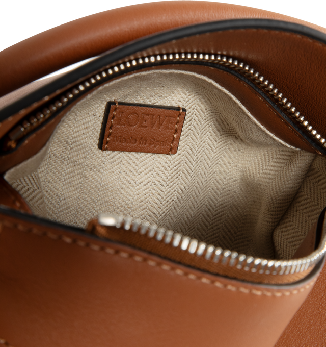 Image 3 of 3 - BROWN - LOEWE Puzzle Bag's cuboid shape and precise cutting technique create distinctive geometric lines. Shoulder, crossbody, top handle or clutch carry. Mini measures 7.1" wide X 4.9" tall. Detachable and adjustable shoulder strap up to 53" long.  Zip closure with calfskin pull, exterior zip rear pocket and one internal slip pocket, herringbone cotton canvas lining and embossed anagram. 100% calfskin leather. 
