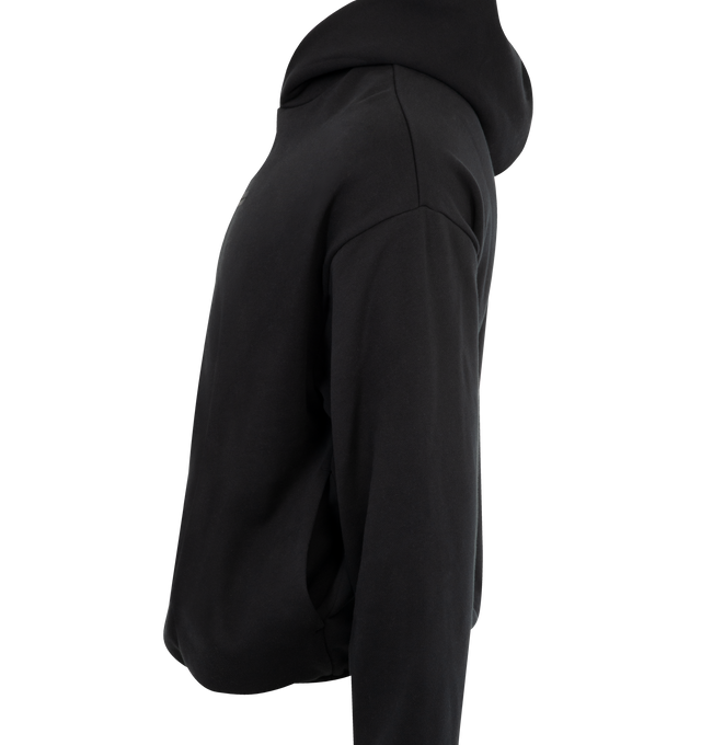 Image 3 of 3 - BLACK - FEAR OF GOD ESSENTIALS Modern Fleece Hoodie featuring 380gsm core fleece, modern fit forming wider relaxed proportions with a cropped length, rubberized labels on the center front and sleeve, double-layer hoodie, side pockets, and elasticized piping on the cuffs and waist hem. 80% cotton, 20% polyester fleece. 