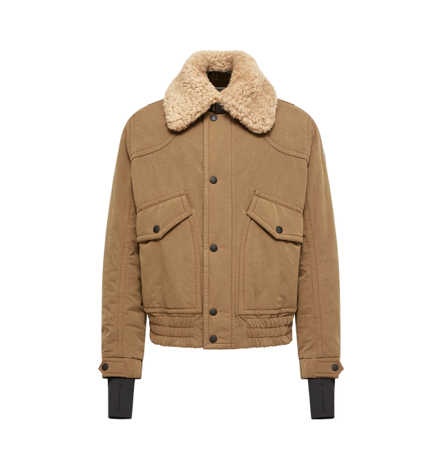Image 1 of 1 - NEUTRAL - Moncler Grenoble Men's Alpental Shearling-Trimmed Canvas Down Bomber Jacket is crafted from a cotton, polyester, and nylon blend canvas and features a rugged bomber silhouette inspired by traditional mountain wear. Designed with a long-haired sheepskin collar, down-filled insulation, and padded detailing at the front, sleeves, and collar, this high-performance jacket balances elevated alpine style with technical functionality. Finished with YKK AquaGuard NATULON water-repellent zipp 