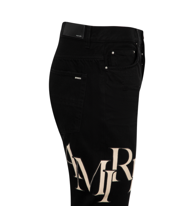 Image 3 of 3 - BLACK - AMIRI Staggered Logo Jeans featuring belt loops, five-pocket styling, button-fly, felted logo appliqu at leg, logo patch at back waistband and logo plaque at back pocket. 92% cotton, 6% elastomultiester, 2% elastane. Made in United States. 