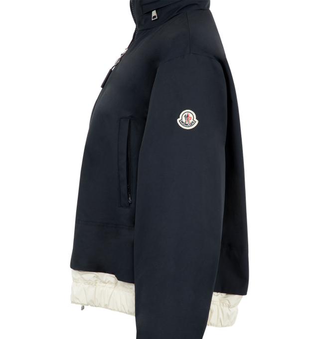 Image 3 of 3 - NAVY - Moncler Janze Pull-Out Hood Jacket has a stand collar with a pull-out drawstring hood, a 2-way zip front closure, an embroidered logo patch, elastic cuffs, side pockets, a relaxed fit, and an elastic hem with snaps. Made in Romania. 