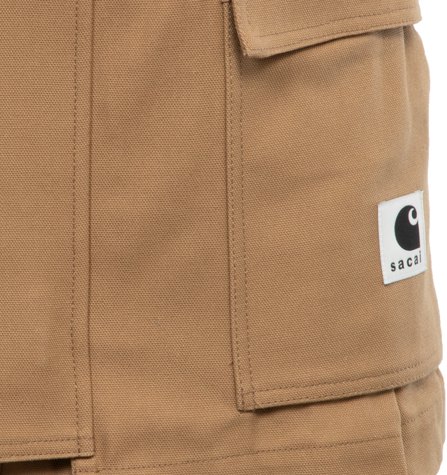 Image 4 of 4 - BROWN - SACAI X CARHARTT WIP Canvas shorts with zip and double button closure, pockets and front logo patch, hammer loop detail at the back pocket,  belt loops, gold tone hardware. Features skirt overlay in front with cargo pockets, zip and button closure. Women's Japanese sizing. JP size 1 = US X-small. JP size 2 = US small. JP size 3 = US medium. JP size 4 = US large.   