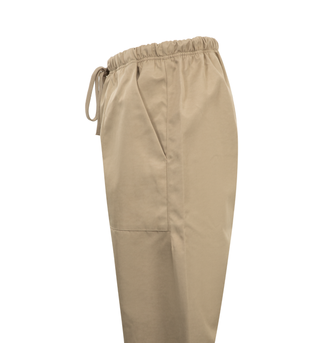 Image 3 of 3 - NEUTRAL - Fear of God Essentials Textured Nylon Utility Pants in a relaxed, baggy fit with wide leg openings. Featuring side seam pockets, textured nylon fabrication, mesh lining, adjustable drawstring waistband and rubber brand label. 