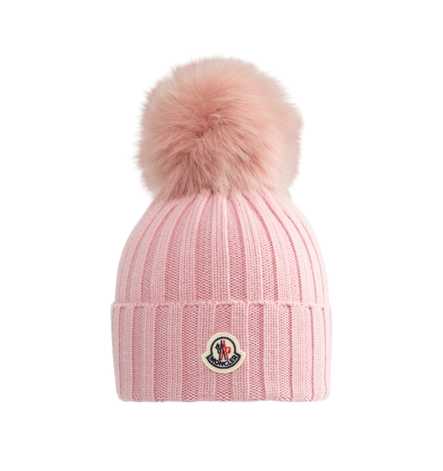 Image 1 of 2 - PINK - Moncler Wool Beanie with Pom Pom features an English rib-knitting and logo at front and embellished with a faux fur pom pom. Designed to provide warmth, this heavy knit beanie for women adds the finishing touch to cold-weather looks. 100% virgin wool . 