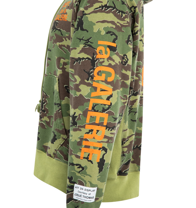 Image 3 of 4 - GREEN - GALLERY DEPT. Dept. De La Galerie Hoodie featuring oversized fit, front pocket, all-over camo print, shrunken FRENCH DPT. logotype on the front, and enlarged on back and sleeves, appliqud with our 'art on display' patch by the cuff and patent wash process that uses unique fading techniques for each piece, inclusive of logos and graphics. 100% cotton. Made in USA. 