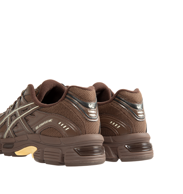 Image 3 of 5 - BROWN - Asics Unisex Emmi x Gel-Stratus MC Sneakers are crafted with synthetic leather overlays and breathable air mesh underlays and feature a streamlined silhouette inspired by technical running footwear. Designed in an exclusive Brown Storm colorway, this collaborative style is equipped with rearfoot GEL technology and GEL-JOG MC-inspired tooling for enhanced cushioning and everyday comfort. Main Material: Synthetic Leather and Mesh. Cushioning: Rearfoot GEL Technology.  
