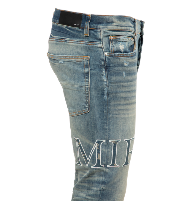 BLUE - AMIRI Core Logo Bandana Jacquard Jean featuring skinny fit jeans, embroidered applique with bandana jacquard textile, stretch denim, distressed finish and five pocket construction. 92% cotton, 6% elastomultiester, 2% elastane. Made in USA. 