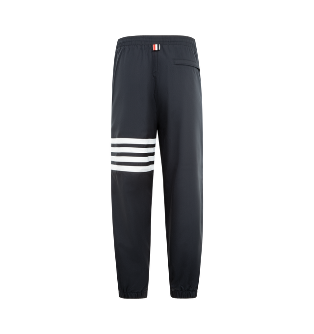 Image 2 of 3 - NAVY - THOM BROWNE Shiny Ripstop 4 Bar Track Pant featuring elasticated waistband with internal drawstring, zip fly, hand pockets and back pocket with hidden zips, elasticated cuffs, mesh lining, 4-bar detailing and signature striped grosgrain loop tab. 81% polyamide, 19% polyester. Made in Italy. 