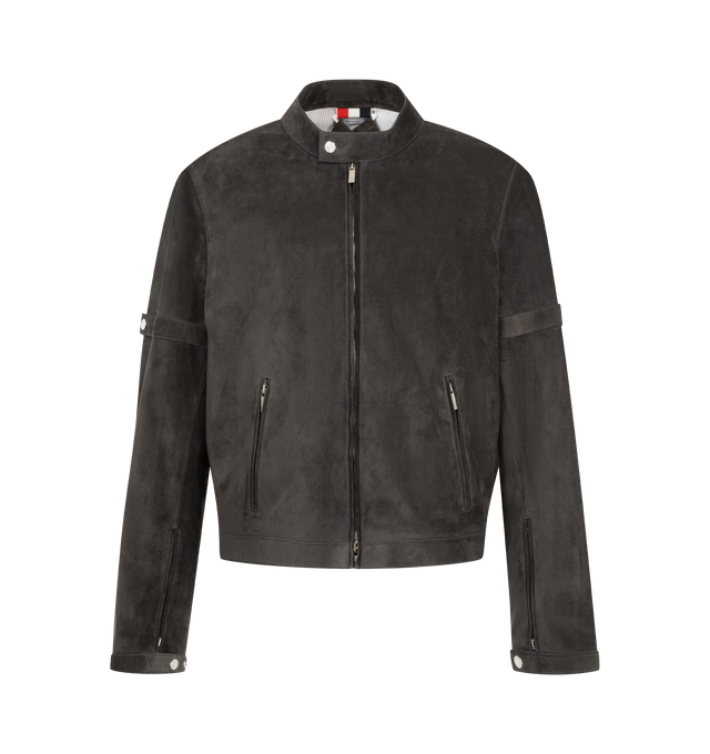 Image 1 of 3 - GREY - Thom Browne Men's Leather Racer Jacket is crafted from calf leather and reimagines the classic racer silhouette through clean lines and refined detailing. Designed with a hidden two-way zip closure, the jacket features a stand collar with a snap-fastening tab, concealed zip hand pockets, an internal pocket, and self snap-fastening armbands that reference the brands signature codes. Zip sleeve vents with snap-tab cuffs, side adjusters, detachable internal backpack straps, and a signatur 