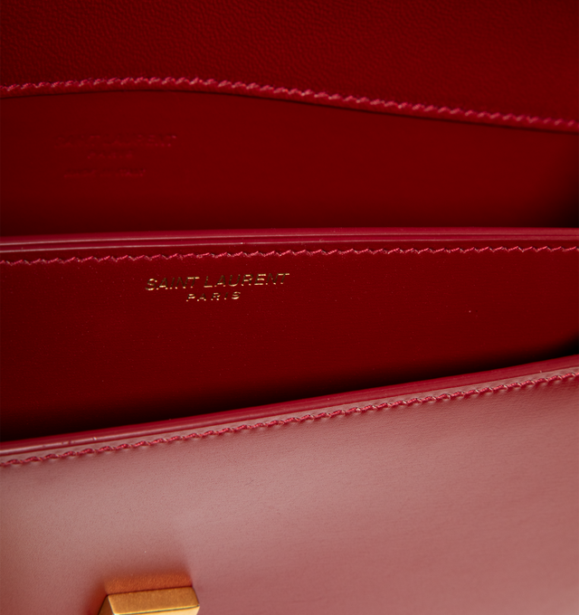 Image 3 of 3 - RED - SAINT LAURENT Voltaire Box Bag featuring half-moon shoulder bag in calfskin with a gently polished finish, flap with pivoting cassandre closure, an adjustable and detachable swivel-hook strap, leather lining, bronze-toned hardware and one flat pocket. 9.4" x 5.9" x 2". Handle drop: 2.4". Strap drop: 10.6". Calfskin leather. Made in Italy. 