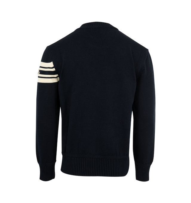 Image 2 of 3 - NAVY - MONCLER Curved Logo Knit Crewneck Sweater featuring embroidered curved logo on the front, logo emblem with stripes on the left sleeve, crew neckline, long sleeves, ribbed cuffs and hem and pullover style. Polyester/leather. Lining: polyester. Made in Bulgaria. 