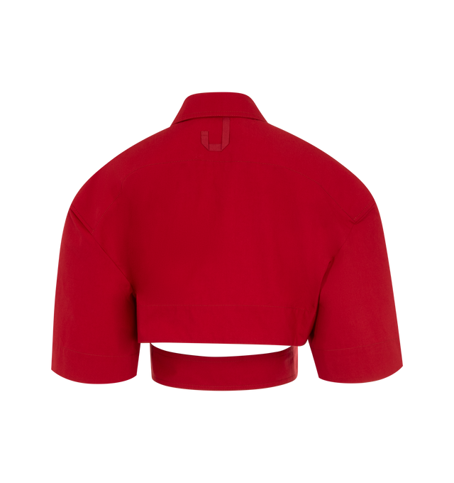 Image 2 of 2 - RED - JACQUEMUS Cropped Belted Shirt featuring cropped fit with boxy shoulders, stretch cotton canvas, pointed collar, asymmetric J shaped chest pocket, hidden button placket with mother-of-pearl buttons, topstitching details, cut-out waist with attached buttoned belt and golden metal belt rings. 94% cotton, 6% elastane. Made in Bulgaria. 