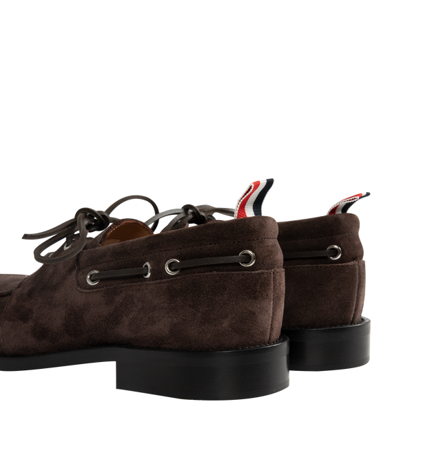 Image 3 of 4 - BROWN - Thom Browne Mens Boat Shoes are crafted from supple calf suede. Feature a lace-up closure, classic boat shoe silhouette, brogue detailing, rubber sole, and signature striped grosgrain loop tab. Main Material: Upper: 100% Calf Suede Leather; Lining: 100% Calf Leather; Sole: 100% Rubber. Made in Italy. 