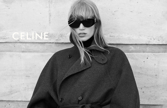 Person wearing a Celine coat and sunglasses against a textured wall.