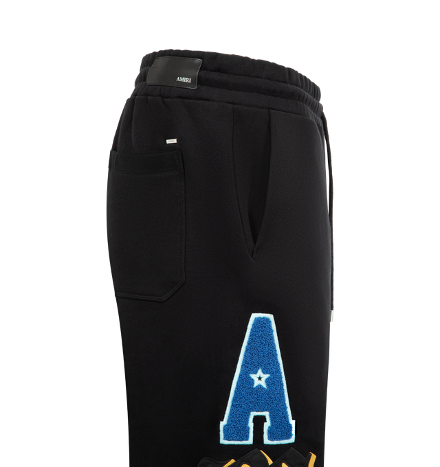 Image 3 of 5 - BLACK - AMIRI Varsity Patch Sweatpant featuring multicoloured appliqus, elasticated waistband with drawstring, relaxed fit, side pockets and back welt pocket. 100% cotton. 