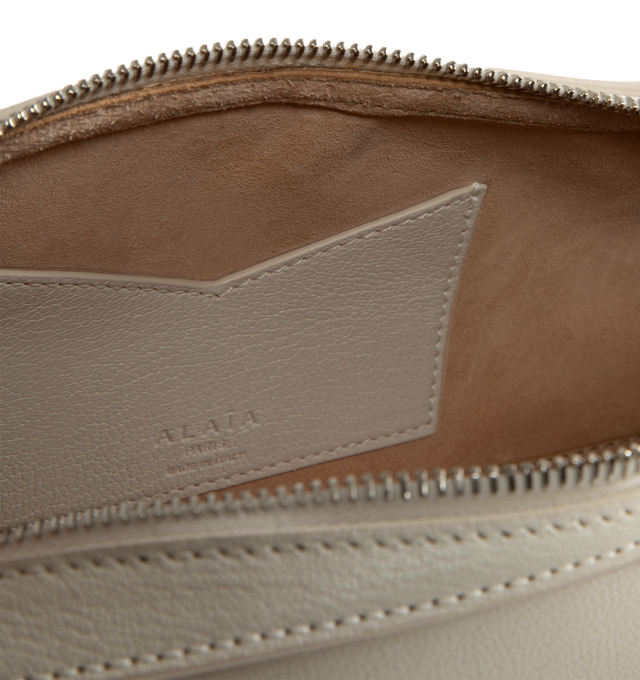 Image 3 of 3 - WHITE - ALAIA LE TECKEL Boston bag with elongated shape featuring long handles signed and held together by 2 decorative fasteners. Features double zip closure, includes a small mirror. Shoulder carry. Dimensions (cm): l 33 x h 11 x d 10. Made in Italy. 