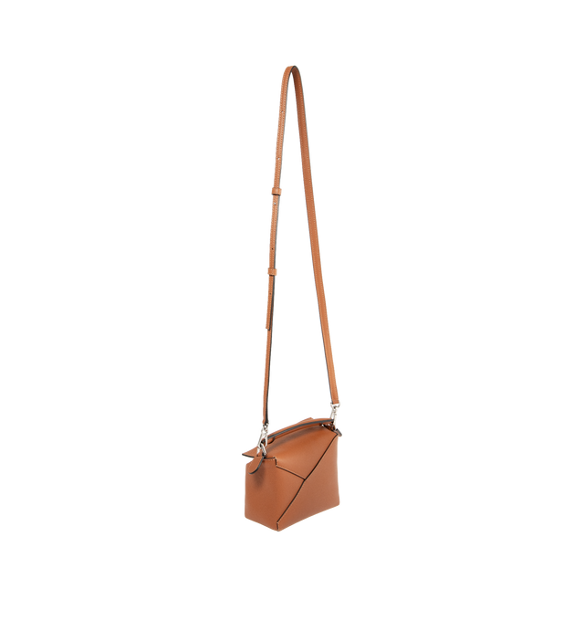 Image 2 of 3 - BROWN - LOEWE Puzzle Bag's cuboid shape and precise cutting technique create distinctive geometric lines. Shoulder, crossbody, top handle or clutch carry. Mini measures 7.1" wide X 4.9" tall. Detachable and adjustable shoulder strap up to 53" long.  Zip closure with calfskin pull, exterior zip rear pocket and one internal slip pocket, herringbone cotton canvas lining and embossed anagram. 100% calfskin leather. 
