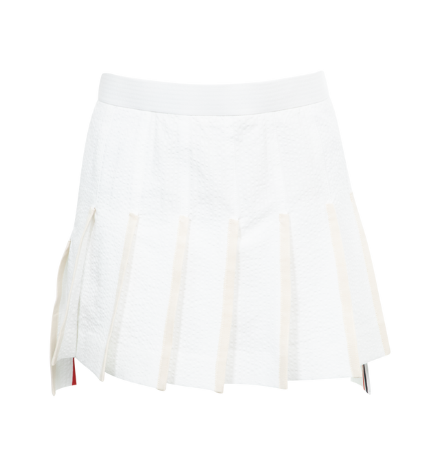 Image 1 of 3 - WHITE - THOM BROWNE Low Rise Mini Pleated Skirt featuring stiff cotton seersucker, back zip-up closure, signature grosgrain lined trim and signature grosgrain loop tab. 100% cotton. Made in Italy. 