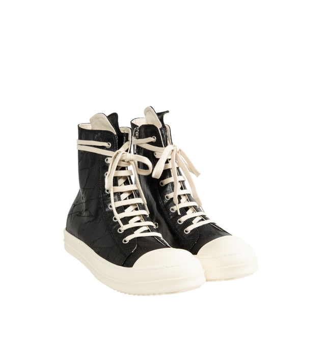 Image 2 of 5 - BLACK - Rick Owens DRKSHDW Men's Sneaks are crafted from 13 oz Megacrust Japanese denim and feature an above-ankle silhouette with eight eyelets, lace-up fastening, an interior ankle zipper, toe caps, and signature shark-tooth soles. Finished with a distinctive Megacrust treatment, the denim is overdyed black, wax-coated, and layered with black foil that naturally cracks and peels over time, creating a uniquely worn appearance with continued wear. Main Material: Upper 100% Cotton. Toe: 70% Po 