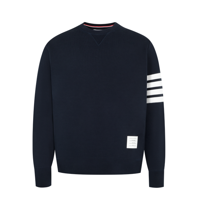 Image 1 of 2 - NAVY - THOM BROWNE Classic Loopback 4-Bar Sweatshirt featuring crew neckline with v patch, engineered 4-bar stripe detail at left sleeve, name tag applique above hem, buttoned side vents with signature striped grosgrain trim and signature striped grosgrain loop tab at back of neck. 100% cotton. Made in Japan. 