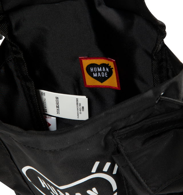 Image 3 of 3 - BLACK - Human Made Military Multi Pouch is crafted from durable nylon and features a compact military-inspired design that can be used alone or attached to compatible Human Made military series bags. Designed with multiple storage compartments, stencil-style graphics, and adjustable attachment points for versatile everyday organization. Main Material: Shell: 100% Nylon. Lining: 100% Polyester. Fits: Phone, wallet, keys, charging cables, cards, passport, and other small daily essentials.  