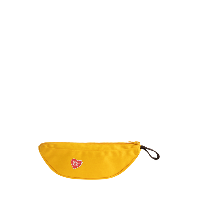 Image 1 of 3 - YELLOW - HUMAN MADE Banana Pouch featuring banana-shaped pouch with a loop attached, made from thick cotton canvas that holds its shape and dye-printed brand logo, fruit sticker style heart logo. 100% cotton.  