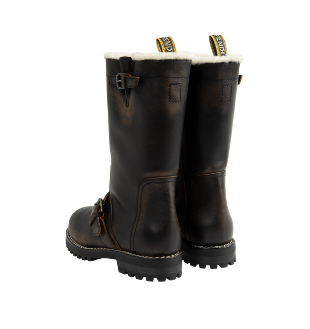 Image 3 of 4 - BROWN - Fendi Women's Commando Boots are crafted from hand-finished antiqued calfskin leather and feature a tubular shaft, adjustable buckle straps at the ankle and calf, and a Fendi Tape pull loop. Designed with clean lines and workwear-inspired hardware, this boot is lined in plush shearling and finished with a lugged rubber sole for traction and durability. Heel Height: 30mm. Main Material: 100% Calfskin. Lining: 100% Lamb Fur Shearling. Sole: Lugged Rubber. Made in Italy. 