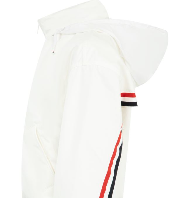Image 4 of 4 - WHITE - THOM BROWNE Nylon Tech Track Jacket featuring front hidden two-way zip closure, stand collar lined with RWB grosgrain, ripstop drawstring hood that folds into collar with hidden zip, welt hand pockets with hidden snap, back storm flap over mesh panel, RWB grosgrain trim along storm flap and back sleeves, elasticated cuffs and hem with channel stitching and signature striped grosgrain loop tab. 51% polyamide, 49% cotton. Made in Italy. 