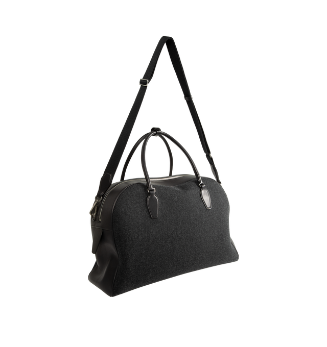 Image 2 of 3 - BLACK - The Row India Travel Bag is crafted from heavyweight felted wool and features a structured travel silhouette with tubular leather handles, smooth calfskin trim, and a zip-top closure. Designed to balance tactile warmth with polished sophistication, this elevated carryall is finished with a branded metal padlock and key, while the compact felted wool construction showcases a subtle mlange texture unique to natural materials. Main Material: 80% Virgin Wool, 20% Calfskin Leather. Lining: 