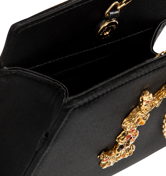 Image 3 of 3 - BLACK - SAINT LAURENT Evening Mini Bracelet Bag in satin featuring small pouch decorated with a hammered cassandre jewel set with sunstone and tiger's eye gemstones, satin lining, snap-button closure and bronze-tone hardware. It may be carried by hand or worn as a bracelet on the wrist with chain strap. 5.7" x 5.5" x 2". Strap drop: 5.9". Viscose, silk, brass. Made in Italy. 