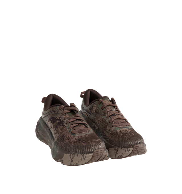 Image 2 of 5 - BROWN - Hoka Unisex Bondi 7 Beams Sneakers reinterpret the ultra-cushioned silhouette with a custom camouflage upper inspired by Japanese Zen gardens. The vegan open-mesh construction features a memory foam collar, TPU overlays, 3D-printed logos, a reflective secondary lace, and a lace keeper. Upper: Vegan Mesh and TPU. *Unisex style in men's sizing. 