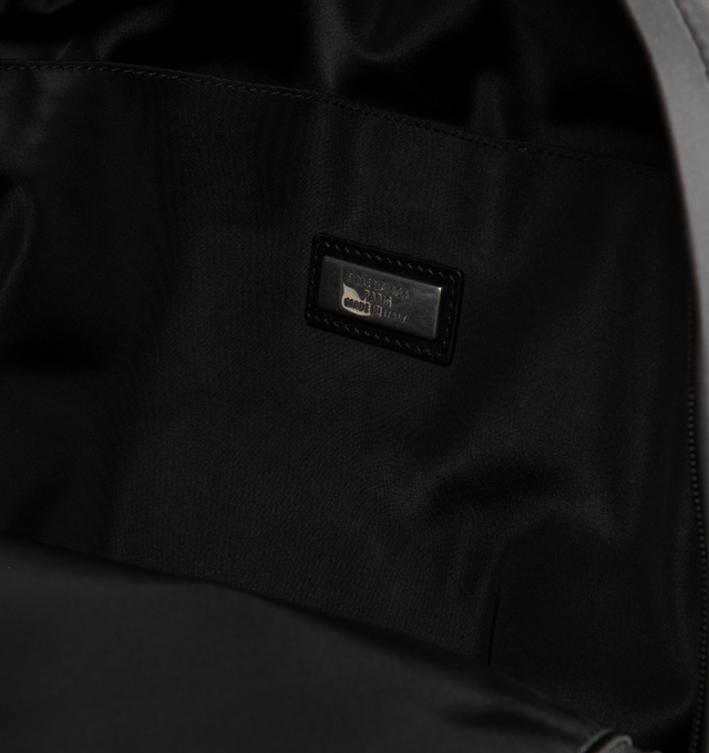 Image 3 of 3 - BLACK - Balenciaga Sleek Mens Nylon Backpack is crafted from black recycled nylon with smooth leather trim and features a zip-around closure and adjustable padded shoulder straps with metal hardware. A circular top handle, front logo print, metal logo plaque, interior pocket, and front compartment with two zippers complete the design. Fits a tablet, notebook, wallet, phone, keys, and small water bottle. Main Material: 100% Recycled Nylon. Leather Detail: Smooth Leather. Dimensions: 30 x 14 x  